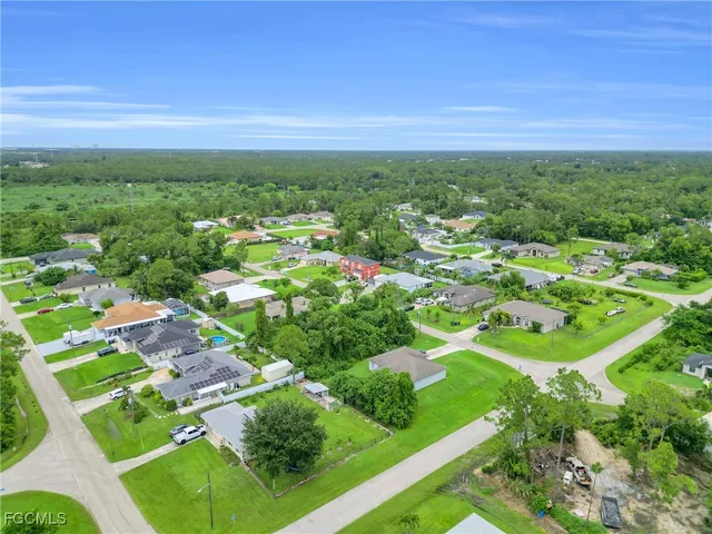 an aerial view of residential houses with outdoor space and trees