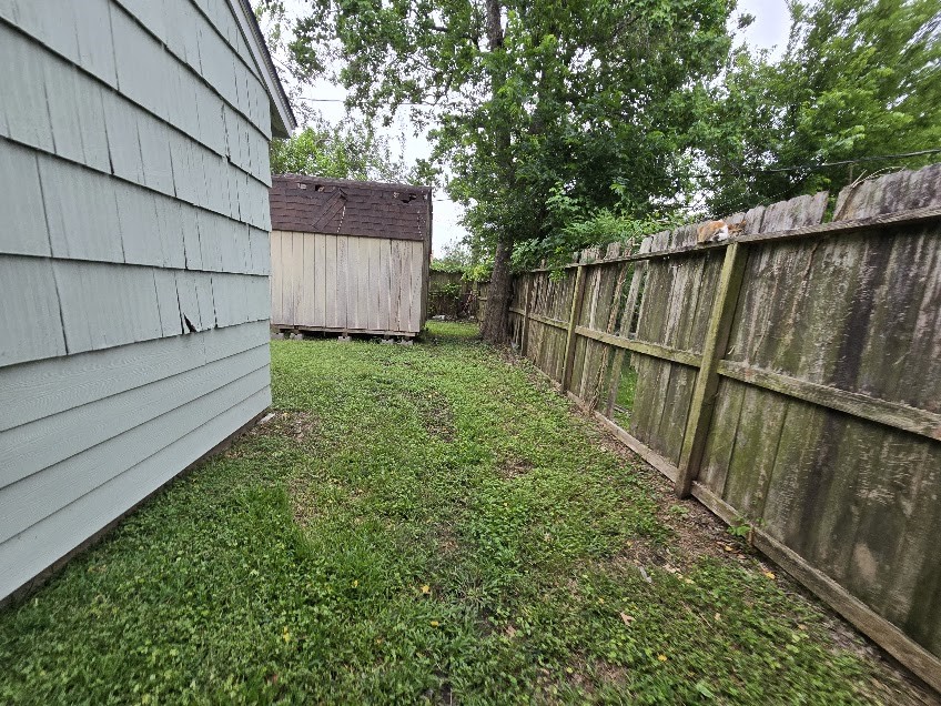 822 Woodhue Street Channelview, TX 77530 - Photo 13 of 14 a view of backyard with wooden fence and large trees