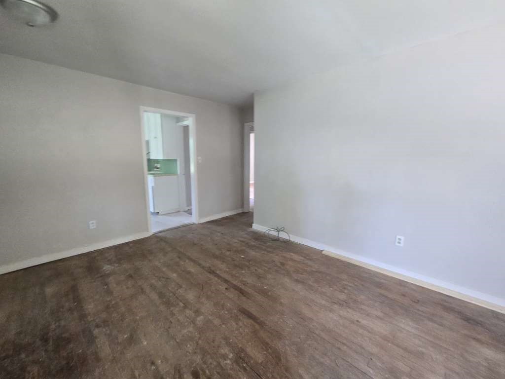 822 Woodhue Street Channelview, TX 77530 - Photo 2 of 14 a view of an empty room with wooden floor and a window