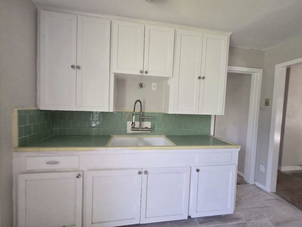 822 Woodhue Street Channelview, TX 77530 - Photo 4 of 11 a kitchen with white cabinets and sink