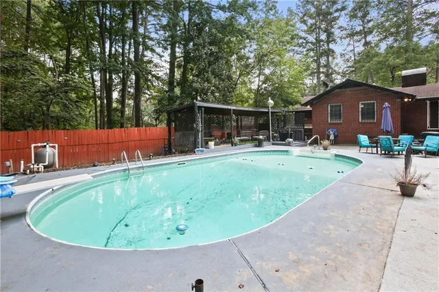a swimming pool with outdoor seating and yard