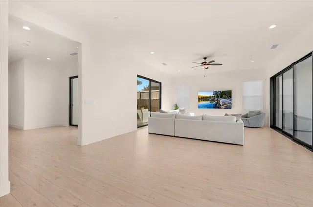 a living room with furniture and a large window with kitchen view