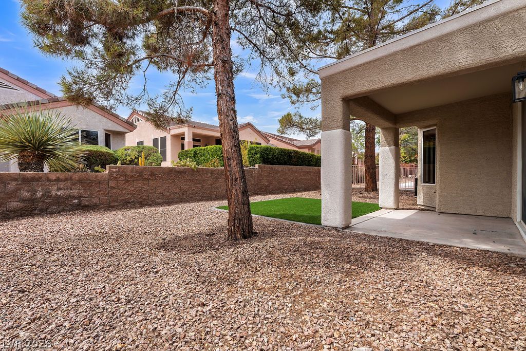 2139 Chapman Ranch Drive Henderson, NV 89012 - Photo 26 of 58 A spacious backyard with a mix of gravel and artificial turf, offering a private outdoor living area.