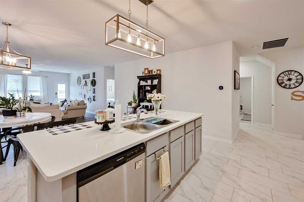 10621 Alpine Meadow Lane Fort Worth, TX 76140 - Photo 16 of 35 a kitchen with a sink a stove and chairs