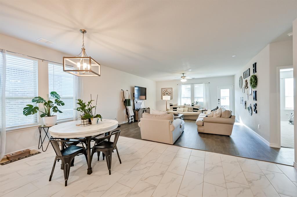10621 Alpine Meadow Lane Fort Worth, TX 76140 - Photo 18 of 35 a living room with couches a table and chairs with potted plants