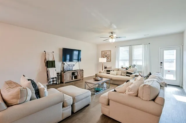 a living room with furniture a flat screen tv and a chandelier
