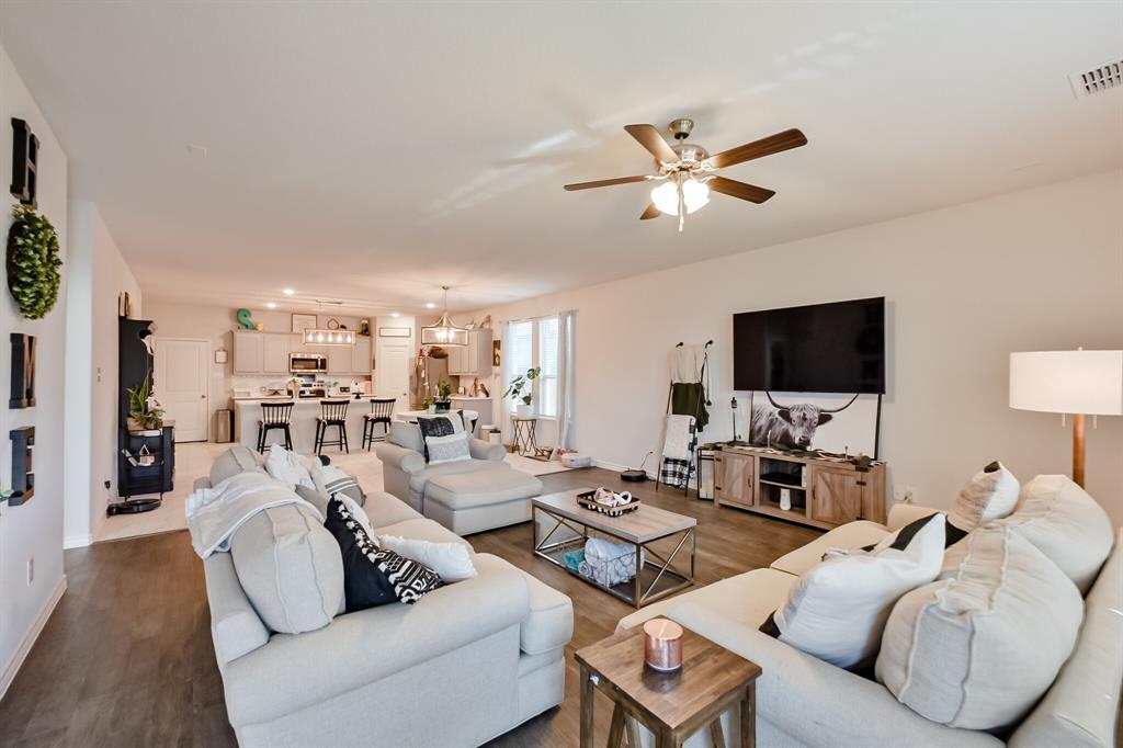 10621 Alpine Meadow Lane Fort Worth, TX 76140 - Photo 21 of 35 a living room with furniture a flat screen tv and a chandelier