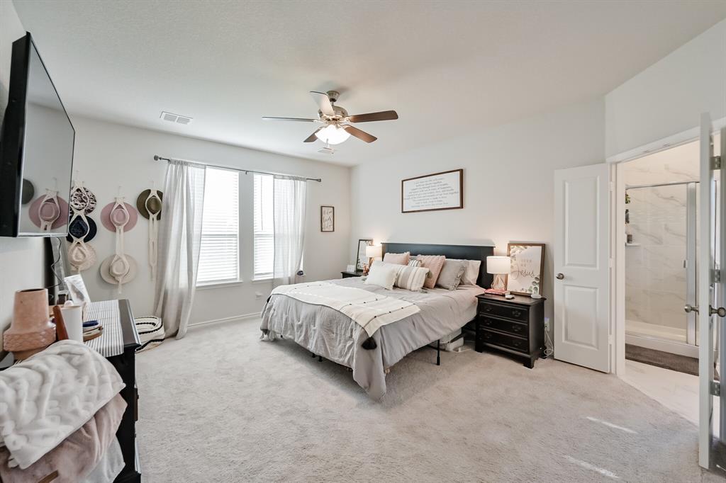 10621 Alpine Meadow Lane Fort Worth, TX 76140 - Photo 24 of 35 a spacious bedroom with a bed and a chandelier
