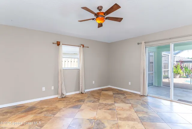 an empty room with a ceiling fan and window