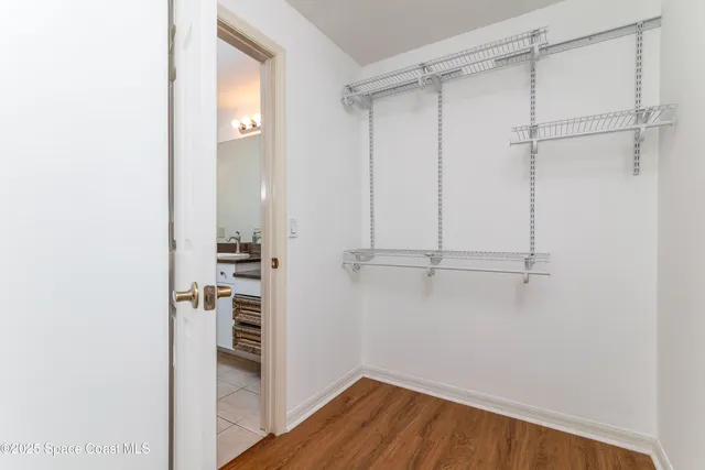 a view of a hallway with wooden floor and a chandelier
