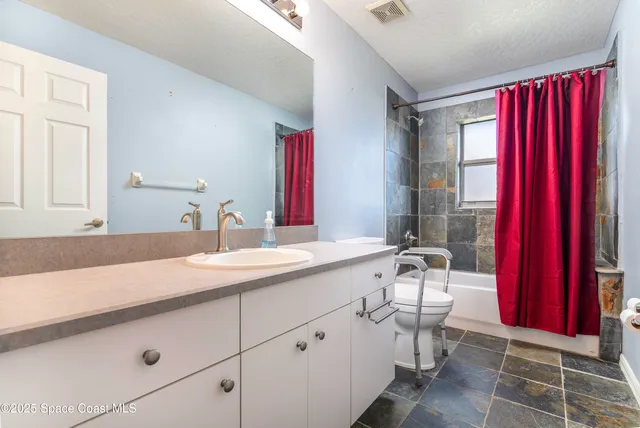 a view of a big room with a ceiling fan and window