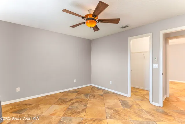 a view of an empty room with a ceiling fan