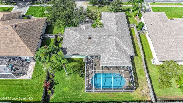 an aerial view of a house with a garden and lake view