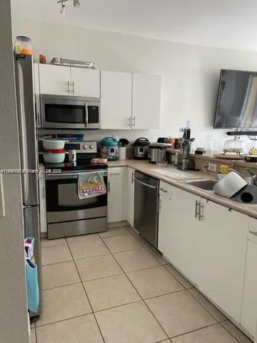 a kitchen with stainless steel appliances granite countertop a sink and a stove