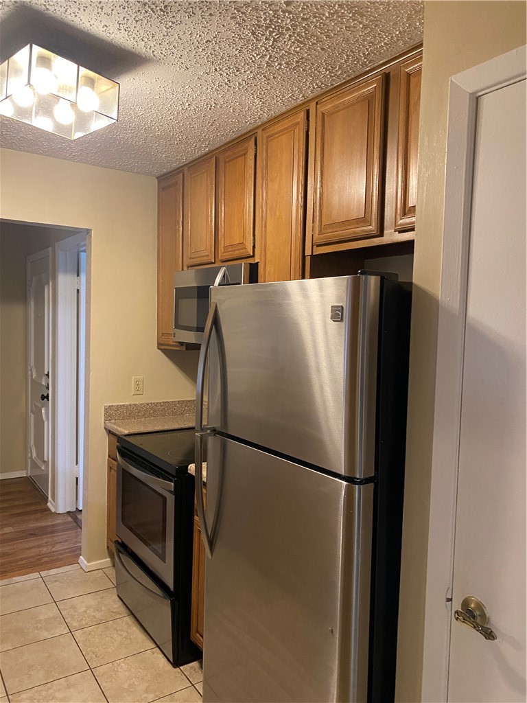 806 West 24th Street, Unit 308 Austin, TX 78705 - Photo 7 of 25 a metallic refrigerator freezer sitting in a kitchen