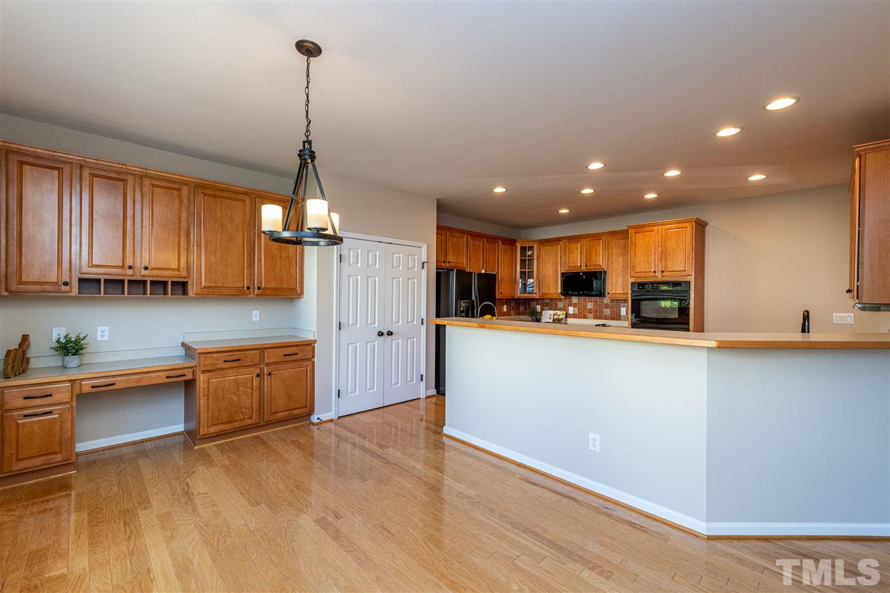 3501 Weir Way Raleigh, NC 27616 - Photo 7 of 30 a kitchen with stainless steel appliances granite countertop a refrigerator a sink dishwasher a stove and a dining table with wooden floor