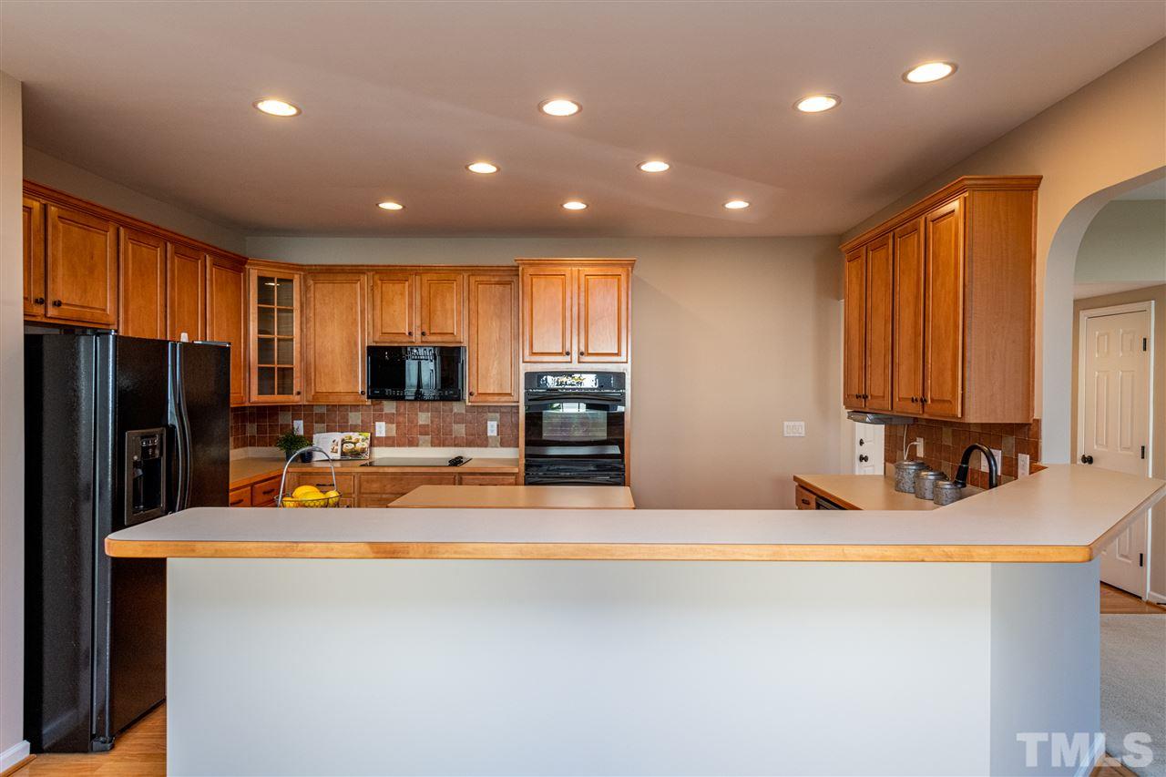 3501 Weir Way Raleigh, NC 27616 - Photo 8 of 30 a view of a kitchen with kitchen island granite countertop a sink a stove and a refrigerator