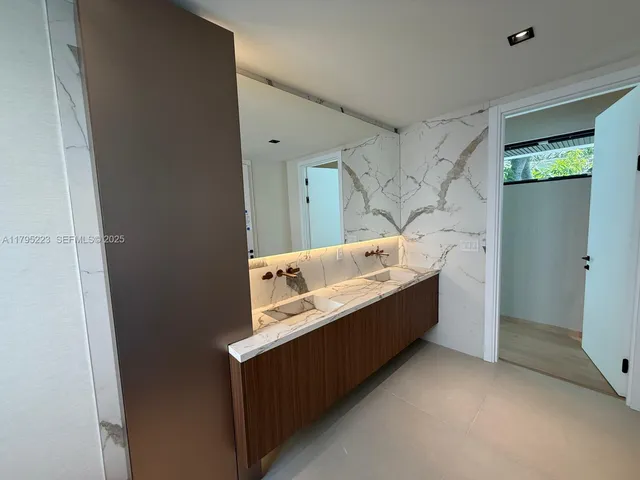 a bathroom with a sink and mirror with toilet