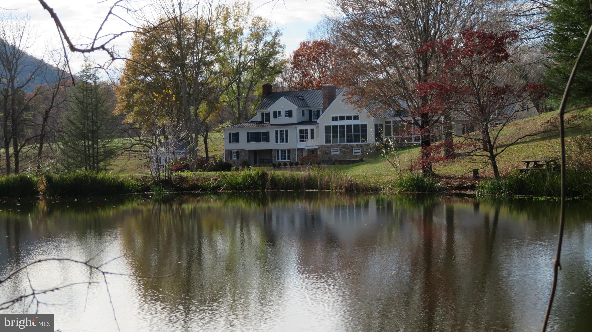 62 Hope Hill Road Castleton, VA 22716 - Photo 72 of 80 a view of a house next to a lake with a large trees