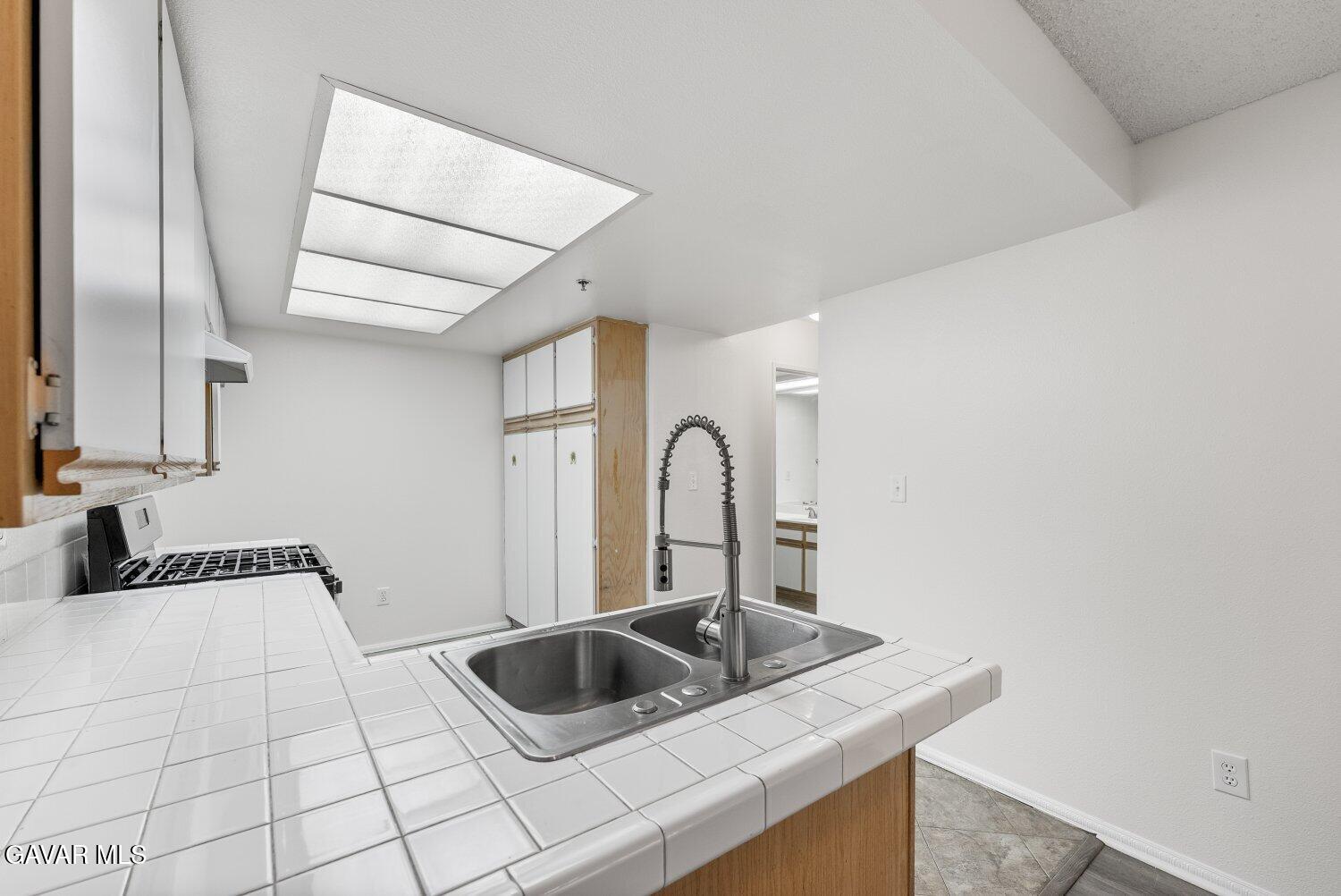 44526 15th Street East, Unit 4 Lancaster, CA 93535 - Photo 16 of 52 a kitchen with a sink and a stove with wooden floor