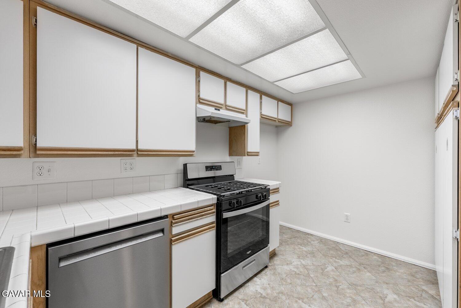 44526 15th Street East, Unit 4 Lancaster, CA 93535 - Photo 17 of 52 a kitchen with stainless steel appliances granite countertop a sink stove and cabinets