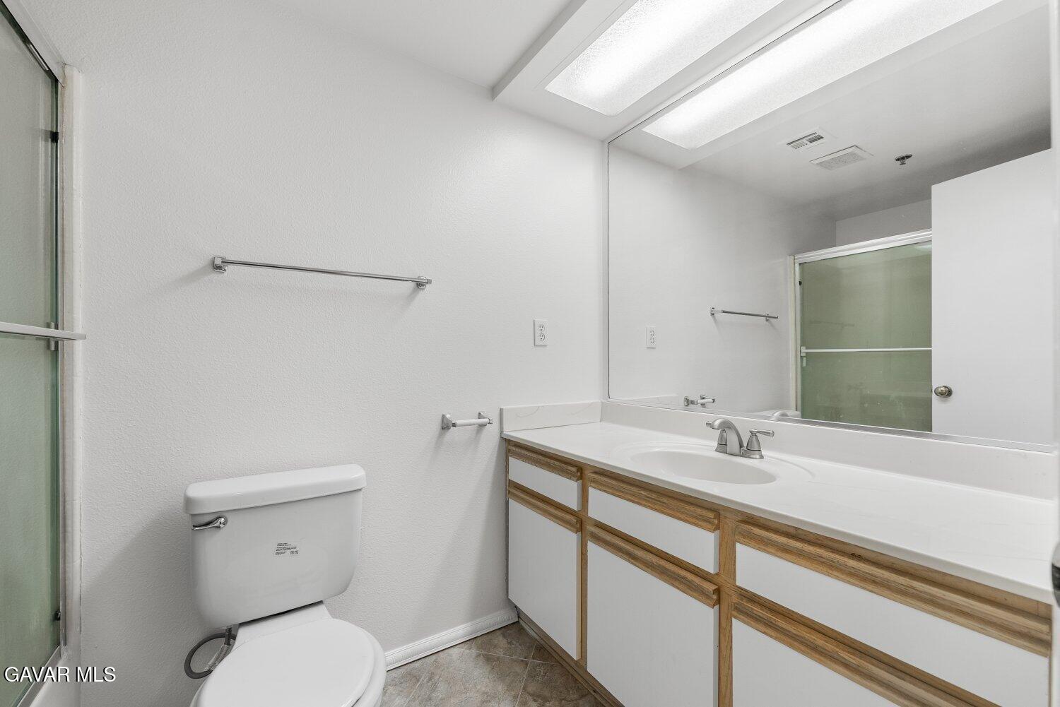 44526 15th Street East, Unit 4 Lancaster, CA 93535 - Photo 25 of 52 a bathroom with a sink a toilet and a large mirror