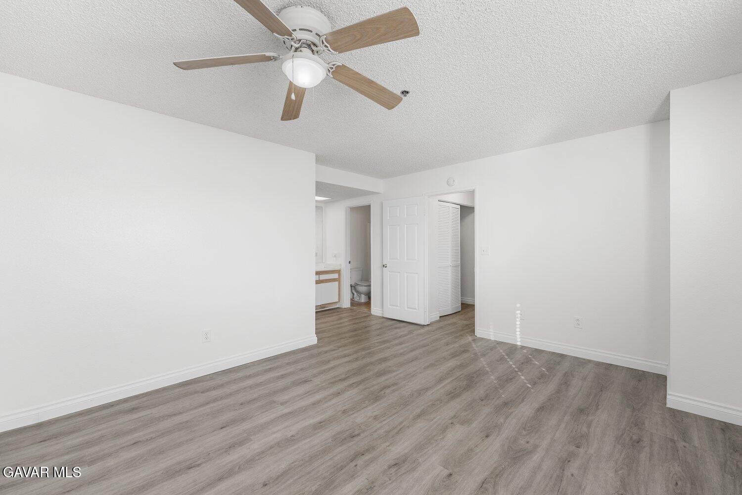44526 15th Street East, Unit 4 Lancaster, CA 93535 - Photo 30 of 52 an empty room with wooden floor a ceiling fan and closet