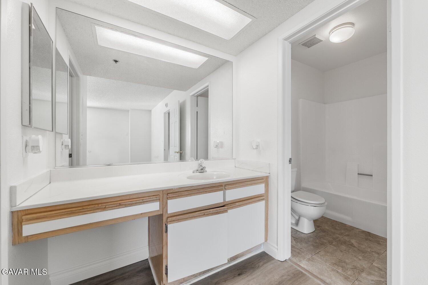 44526 15th Street East, Unit 4 Lancaster, CA 93535 - Photo 32 of 52 a bathroom with a sink a toilet a large mirror and shower