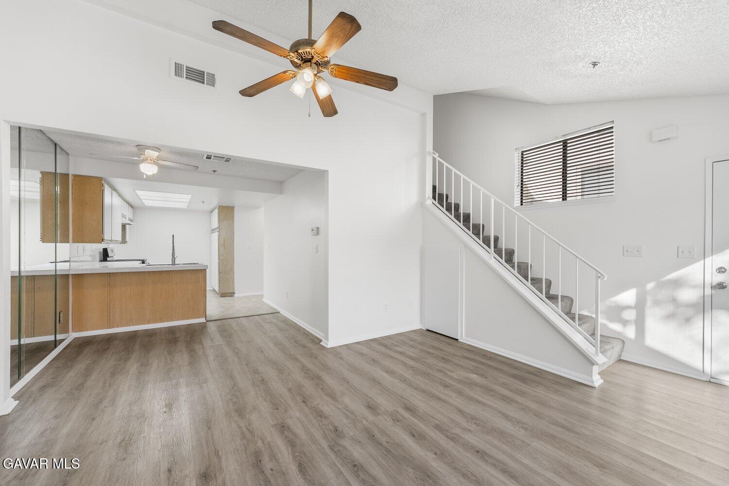 44526 15th Street East, Unit 4 Lancaster, CA 93535 - Photo 8 of 52 a view of an empty room with wooden floor and a kitchen view