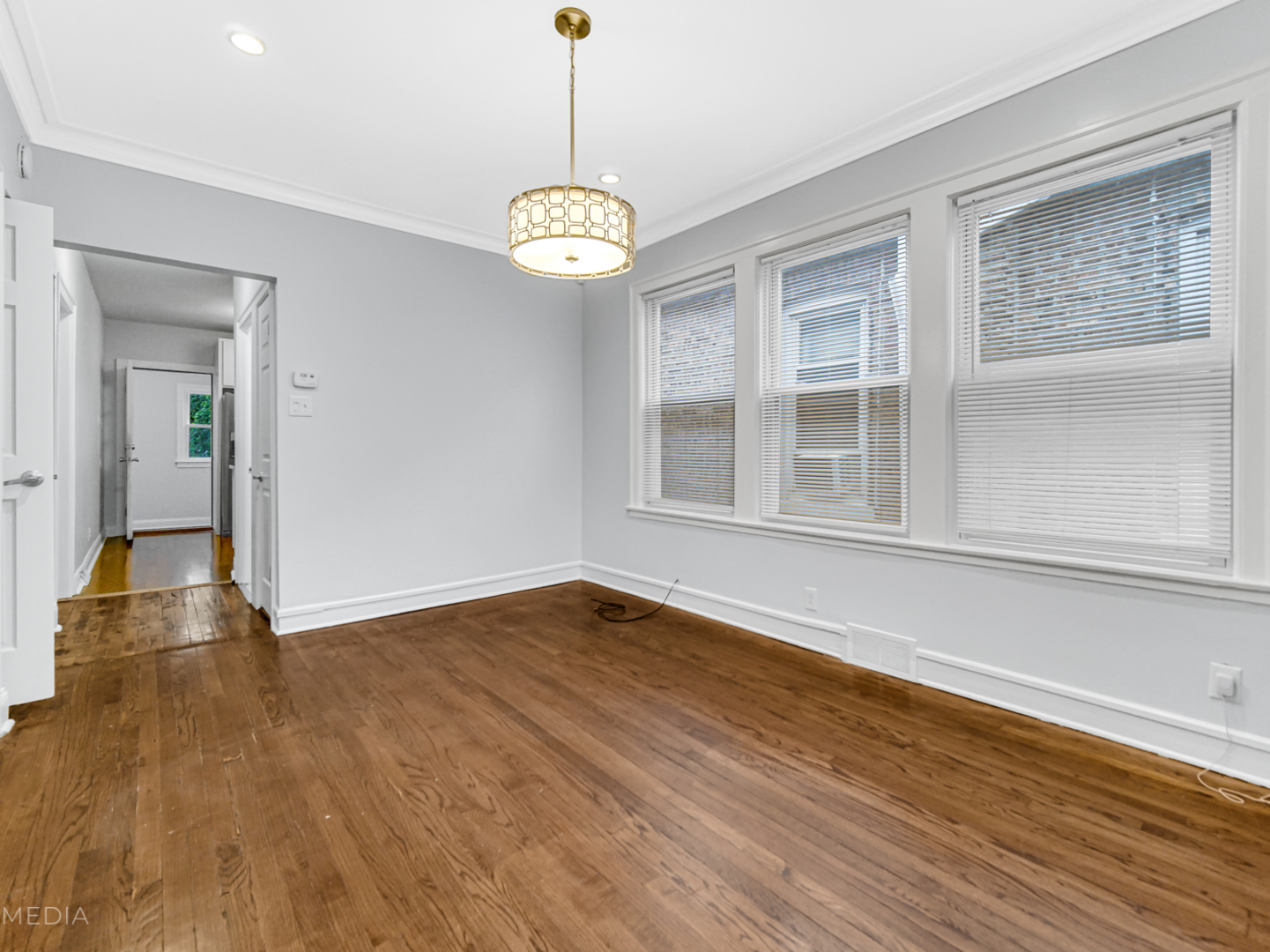 8553 South Sangamon Street Chicago, IL 60620 - Photo 3 of 27 a view of an empty room with wooden floor and a window