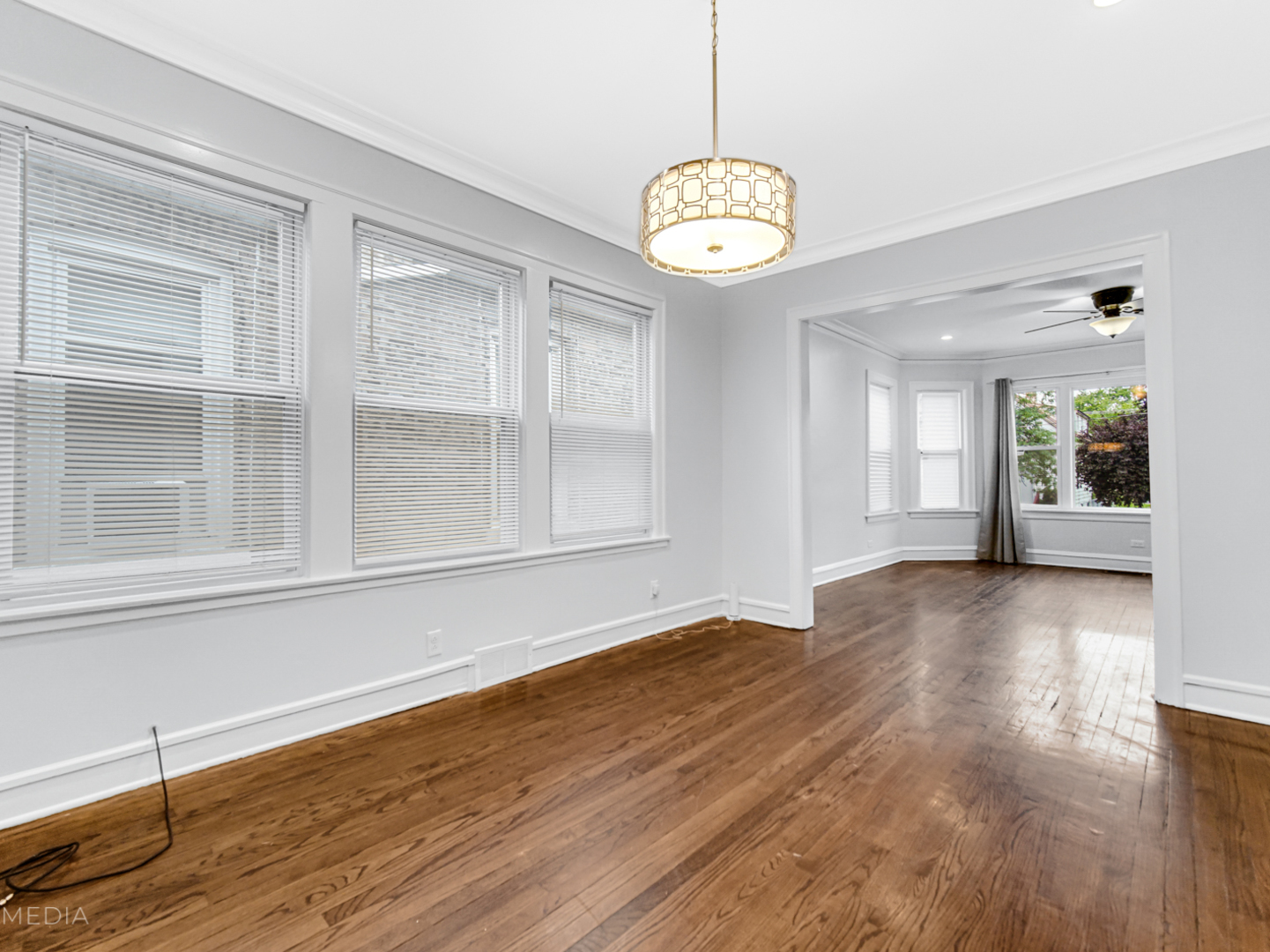 8553 South Sangamon Street Chicago, IL 60620 - Photo 8 of 27 a view of an empty room with wooden floor and windows