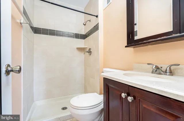 a bathroom with a granite countertop sink toilet and shower