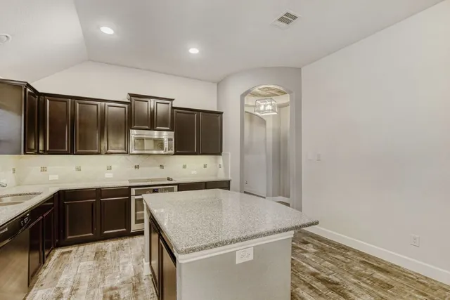 a kitchen with stainless steel appliances granite countertop a sink and a stove