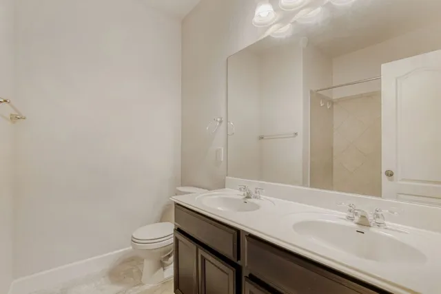 a bathroom with a sink a toilet mirror and vanity