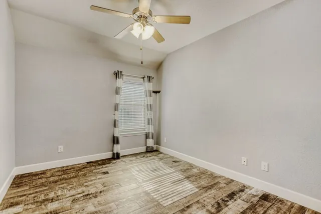 an empty room with a empty space and a ceiling fan