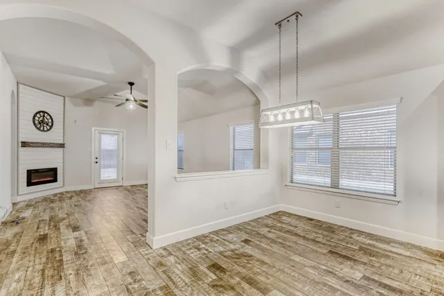 a view of an empty room with a fireplace and a window