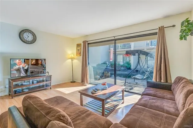 a living room with furniture a flat screen tv and a floor to ceiling window