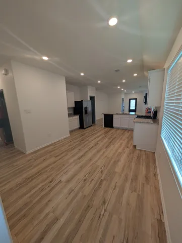 a view of empty room with wooden floor