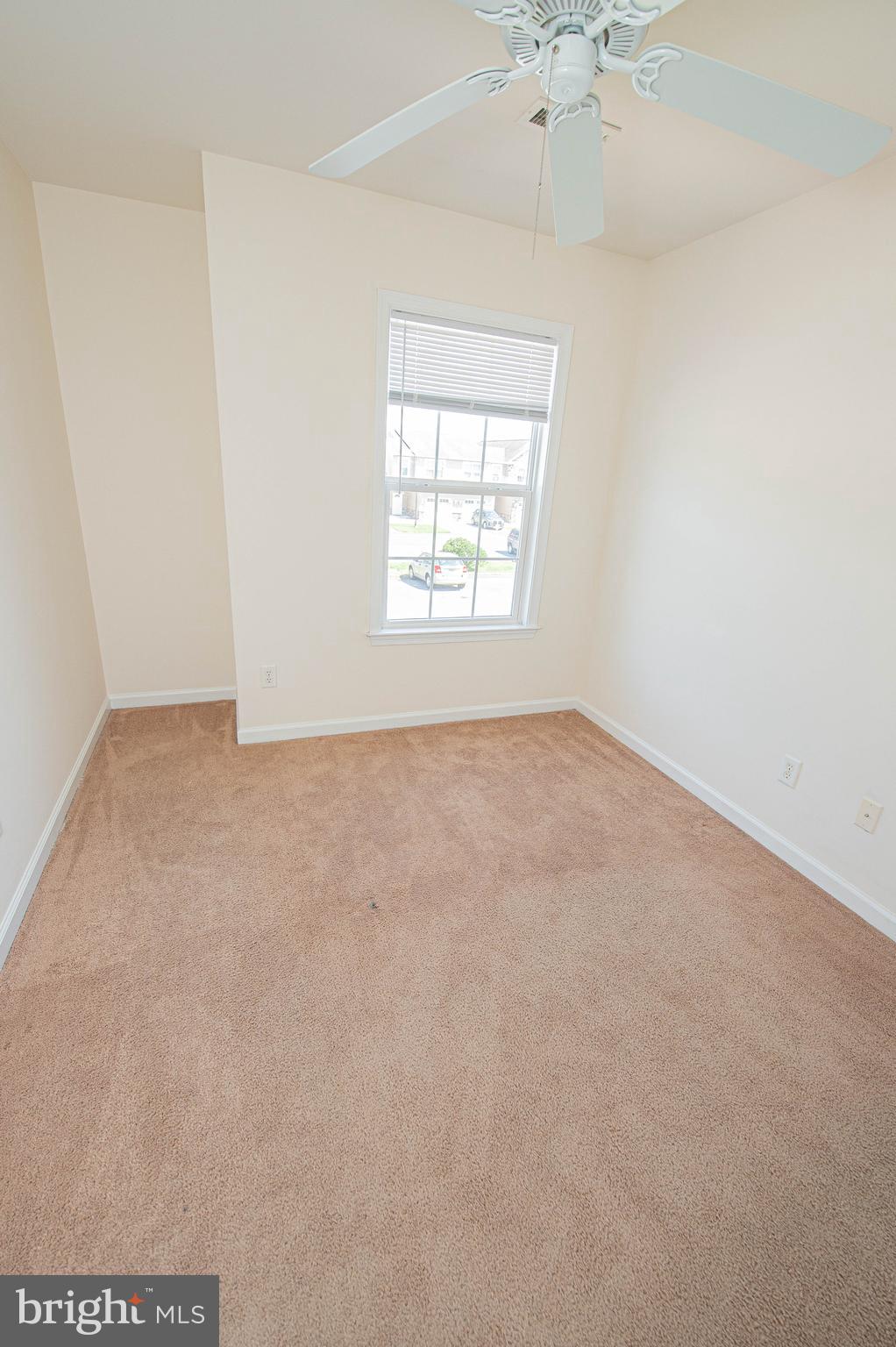 420 Parkview Court, Unit F Salisbury, MD 21804 - Photo 69 of 87 an empty room with a chandelier fan and windows
