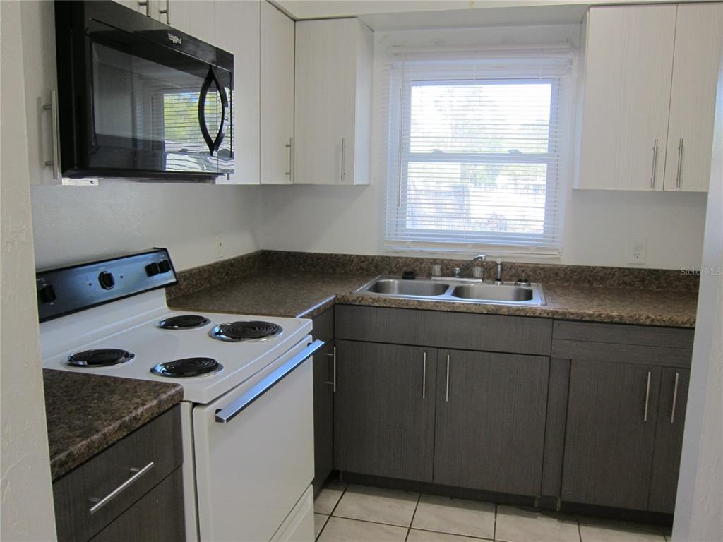 6417 Southwest 9th Avenue, Unit D Gainesville, FL 32607 - Photo 21 of 25 a kitchen with sink cabinets and a stove top oven