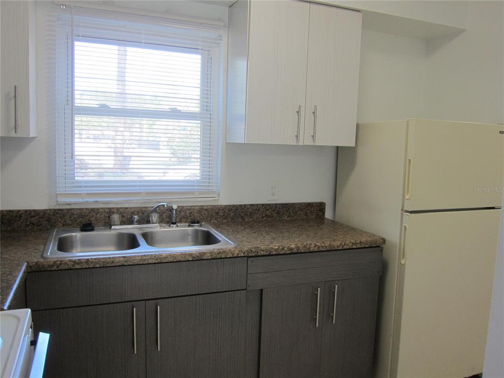6417 Southwest 9th Avenue, Unit D Gainesville, FL 32607 - Photo 22 of 25 a kitchen with granite countertop cabinets sink and window