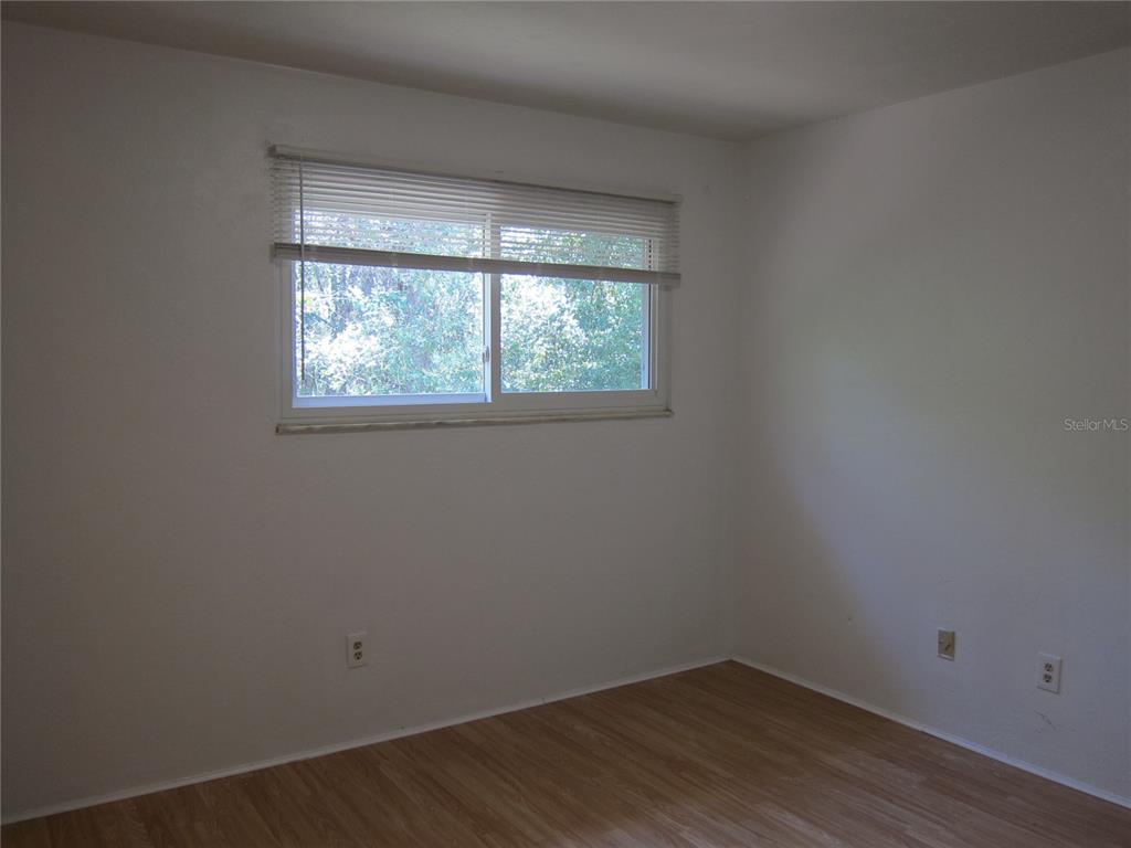 6417 Southwest 9th Avenue, Unit D Gainesville, FL 32607 - Photo 8 of 25 an empty room with wooden floor and windows