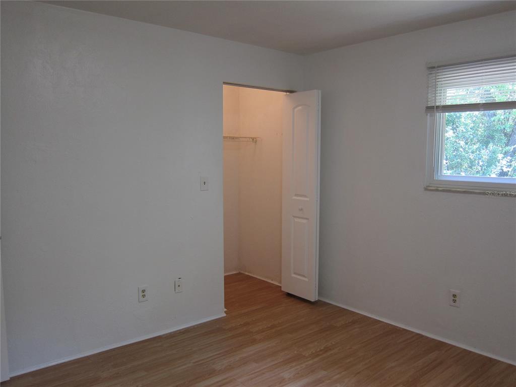 6417 Southwest 9th Avenue, Unit D Gainesville, FL 32607 - Photo 9 of 25 a view of an empty room with wooden floor and a window