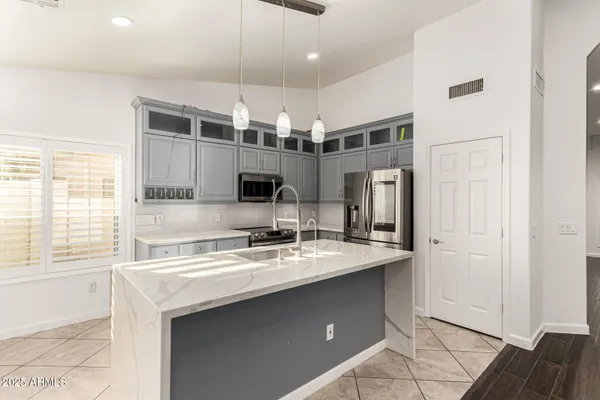 a kitchen with stainless steel appliances granite countertop white cabinets and black stove top oven