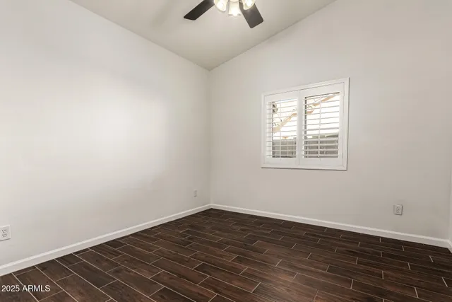 a view of an empty room with wooden floor and closet