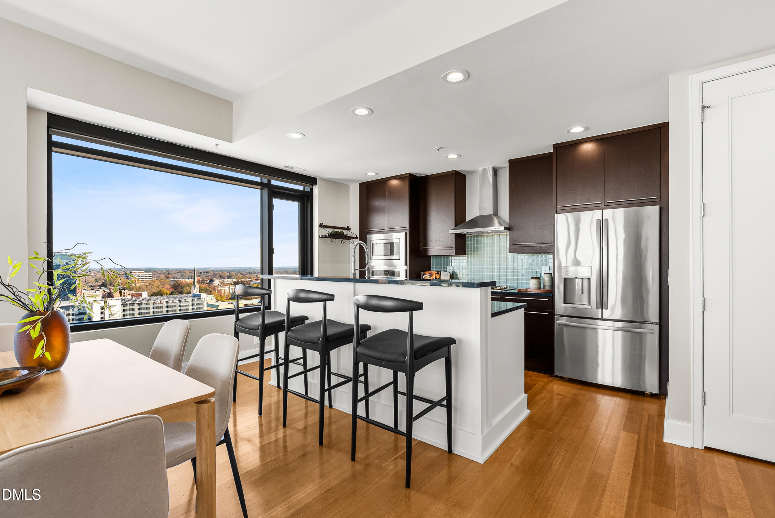 122 North Harrington Street Raleigh, NC 27603 - Photo 10 of 46 a kitchen with stainless steel appliances granite countertop a refrigerator a stove a sink a dining table and chairs with wooden floor