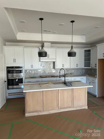 a kitchen with stainless steel appliances granite countertop a sink a stove and cabinets