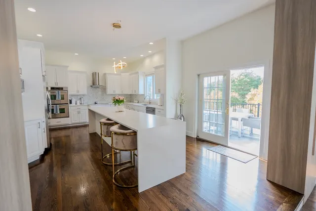 a kitchen with kitchen island stainless steel appliances a stove a sink a refrigerator and cabinets