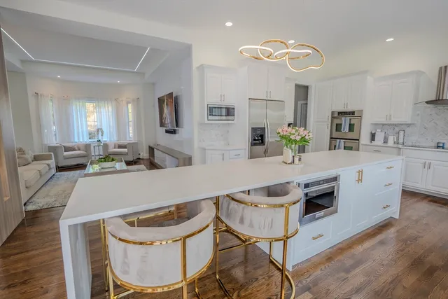 a kitchen with a table chairs microwave and cabinets