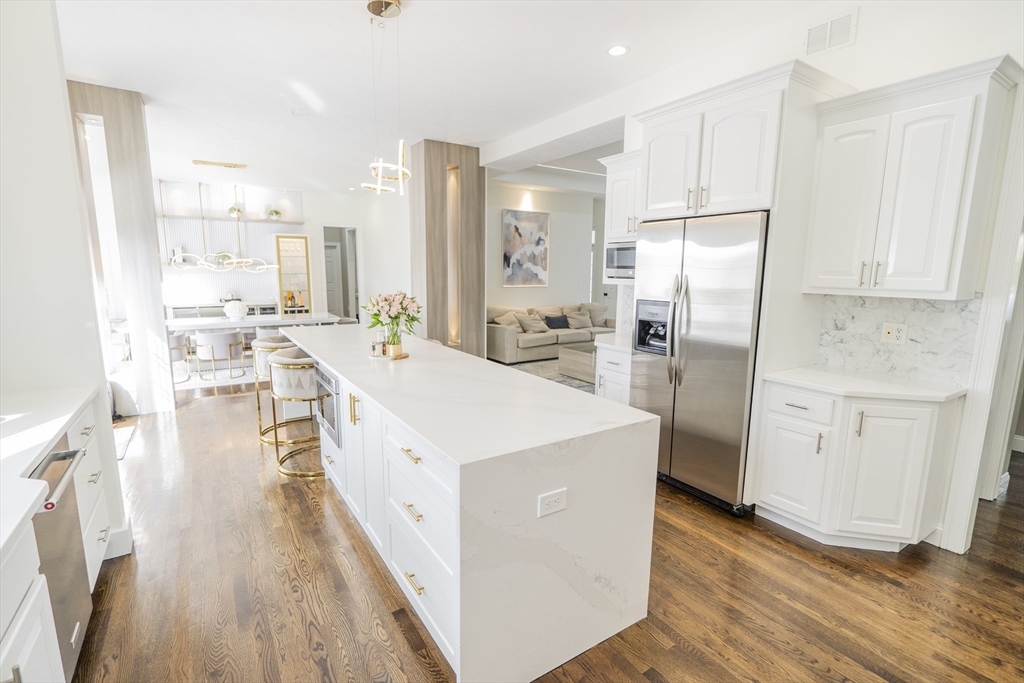 25 Collins Road Berlin, MA 01503 - Photo 14 of 38 a large kitchen with stainless steel appliances a refrigerator a stove a sink dishwasher and white cabinets with wooden floor
